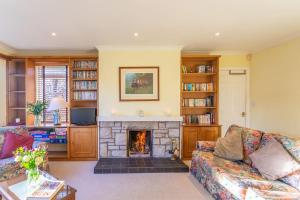 uma sala de estar com um sofá e uma lareira em PleasantHillScotland-Stunning 7BR GardenVilla Superior Area (Sleeps24) em Milngavie