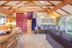 een woonkamer en een keuken met een bank en een tafel bij PleasantHillScotland-Stunning 7BR GardenVilla Superior Area (Sleeps24) in Milngavie
