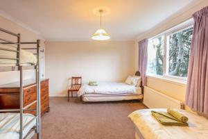 een slaapkamer met 2 stapelbedden en een raam bij PleasantHillScotland-Stunning 7BR GardenVilla Superior Area (Sleeps24) in Milngavie