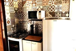 a kitchen with a refrigerator and a stove and a microwave at São Francisco do Sul, SC, Praia do Forte. in São Francisco do Sul