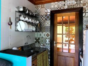 a small kitchen with a sink and a door at São Francisco do Sul, SC, Praia do Forte. in São Francisco do Sul