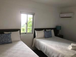 sypialnia z 2 łóżkami i oknem w obiekcie Apartamento en Río San Juan a 4 minutos de playas piscina con agua caliente w mieście Río San Juan