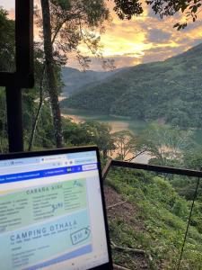 a laptop computer sitting in front of a view of a river at SELVA ADENTRO in Norcasia