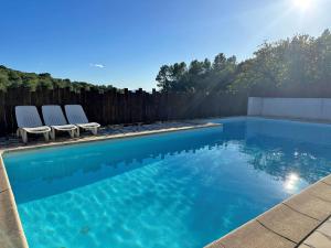 una piscina con 2 sillas y una valla en La Casserina, en Lorgues