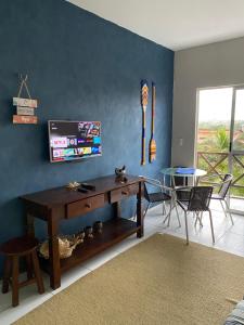 a living room with a wooden table and a blue wall at Apto Praia da Taíba Vista Mar in Taíba