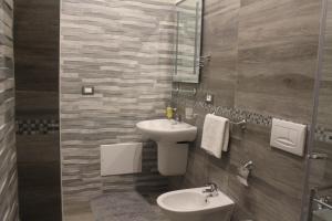 bagno con lavandino, servizi igienici e specchio di Appartamenti Sole&Mare a Polignano a Mare