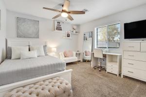 鳳凰城的住宿－Serenity on Sharon，一间卧室配有一张带吊扇的床和一张书桌。