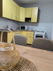 a kitchen with yellow cabinets and a table with a basket at Apartman - GOLEMI MOST in Pirot