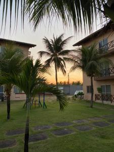 een park met palmbomen en een gebouw en een speeltuin bij Apto Praia da Taíba Vista Mar in Taíba