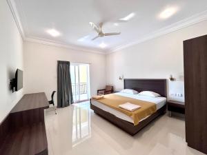 a bedroom with a bed and a ceiling fan at Morjim Sunset Guesthouse- Apartments with Kitchen in Morjim