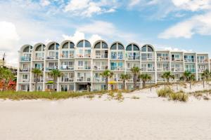 a large white building on the beach with the sand at Blue Haven Villa in Panama City Beach