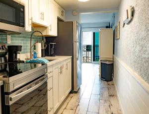 una cucina con armadi bianchi e frigorifero in acciaio inossidabile di Blue Haven Villa a Panama City Beach