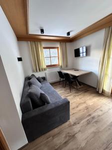 ein Wohnzimmer mit einem Sofa und einem Tisch in der Unterkunft Apartment Steinbock in Samnaun