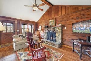 a living room with a fireplace and a tv at Log cabin on peaceful river in Blowing Rock