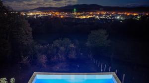 a view of a city at night with a swimming pool at Zivinice Hills in Živinice