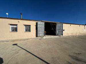 un edificio con dos puertas de garaje en un aparcamiento en Finca Aideta- casa confortable con barbacoa, 