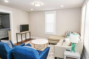 a living room with blue chairs and a couch at Sunny Hill Cottage with 4 Beds in Lincolnton