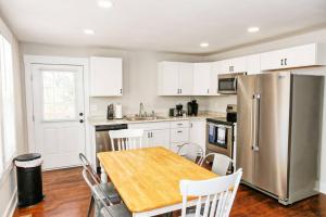 a kitchen with a wooden table and a stainless steel refrigerator at Sunny Hill Cottage with 4 Beds in Lincolnton