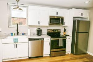 a kitchen with white cabinets and stainless steel appliances at Newly Renovated Small Town Retreat in Maiden +11 photos