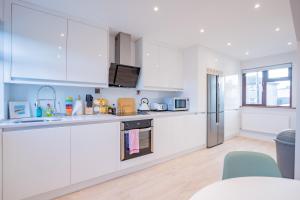 a kitchen with white cabinets and a counter top at City Centre House With Parking in Galway