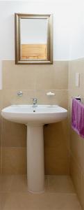 y baño con lavabo blanco y espejo. en Cabañas Tilcara Taki en Tilcara