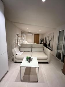 een woonkamer met een witte bank en een tafel bij Lalola villas - Casa privada Denia in Denia