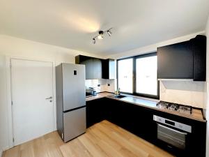 a kitchen with a stainless steel refrigerator and black cabinets at Chalet IriMa in Copalnic