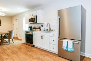 a kitchen with a stainless steel refrigerator and a table at Farm Lodge with Beautiful Open Floor Plan in Lincolnton