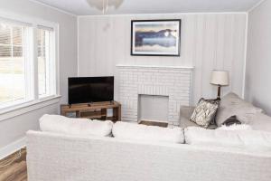 a living room with a white couch and a fireplace at Newly Renovated Salem Road Ranch in Lincolnton