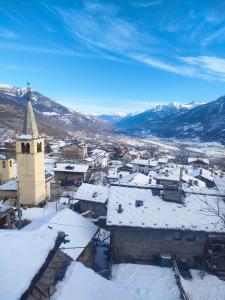 a town covered in snow with a church at Maison du Mont in Aosta