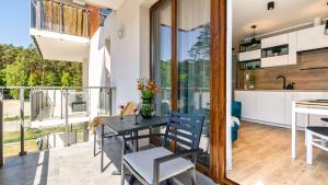 a kitchen and dining room with a table and chairs at STEGNA PARK B Apartamenty PIAMOLA in Stegna