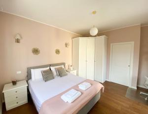 - une chambre avec un lit blanc et 2 serviettes dans l'établissement Casa Ludmila, à Corsico