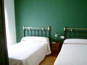 2 łóżka w pokoju z zielonymi ścianami w obiekcie El Rincon del Labrador w mieście La Santa Espina
