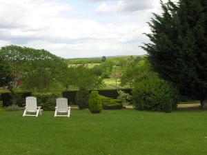 two white chairs sitting in a field of grass at Chez Annie in Saint-Avit-Rivière