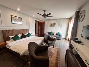 a bedroom with a bed and two chairs and a couch at Elegant Executive Suite in Multan