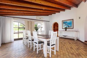 Un comedor con una mesa y sillas blancas. en Summer Lodge Villa 1, en Uvongo Beach