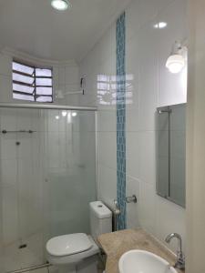 a bathroom with a toilet and a shower and a sink at Solar Poranga in Santarém