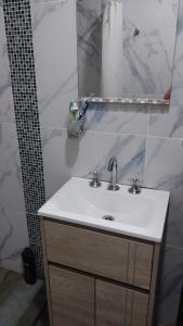 a bathroom with a sink and a mirror at La morada del arroyo in Villa Santa Cruz del Lago