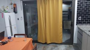 a yellow curtain in a kitchen with a table at La morada del arroyo in Villa Santa Cruz del Lago +10 photos