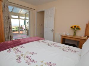 a bedroom with a large bed with a vase of flowers at 1 bed in Bude SCADG in Poughill