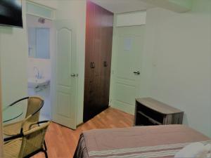 a bedroom with a bed and a bathroom with a sink at HOTEL MURCIA AREQUIPA in Arequipa