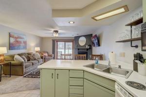 a kitchen with a sink and a living room at Stephs Waterfront Retreat Sunset Cove 303 in Wisconsin Dells