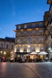 um grande edifício com mesas e guarda-sóis em frente em Porto A.S. 1829 Hotel no Porto