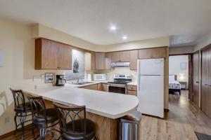 a kitchen with a white refrigerator and wooden cabinets at Piers and Pines at Island Pointe in Wisconsin Dells