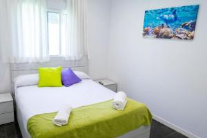 a bedroom with a white bed with yellow and purple pillows at VILLA 5 PLAYA A 2 MINUTOS in Castelldefels +57 photos