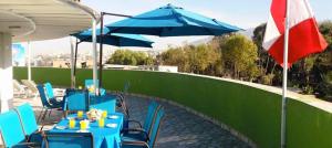 a blue table with chairs and umbrellas next to a fence at HOTEL MURCIA AREQUIPA in Arequipa