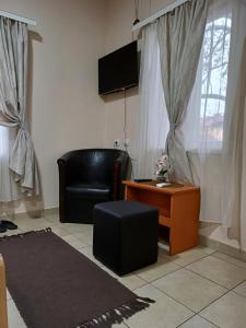 a living room with a black leather chair and a table at Sobe SANjA in Pirot