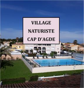 un grande cartello che legge il villaggio di nantucketcapapeake. di Chambres d'Hotes NATURISTE, Village Naturiste Cap d'Agde, Draps, Serviette, Café, Menage inclus en fin de sejour a Cap d'Agde