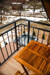 eine Holzbank auf einem Balkon mit Schnee auf dem Boden in der Unterkunft Zenit Chalet Sohodol-Bran in Sohodol