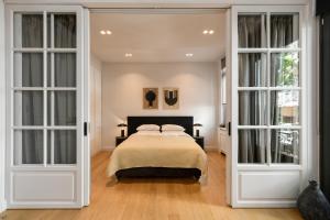 a bedroom with a bed and two french doors at Boutique Archaeological Museum Suites in Athens